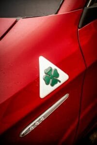 a green and white triangle with a four leaf clover on a red car